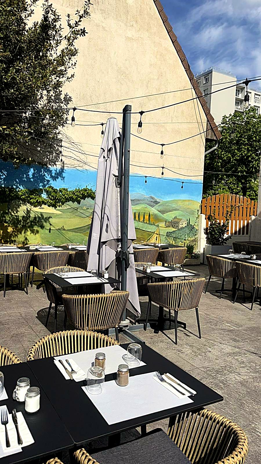 Terrasse de L'Authentique avec guirlandes lumineuses et fresque toscane